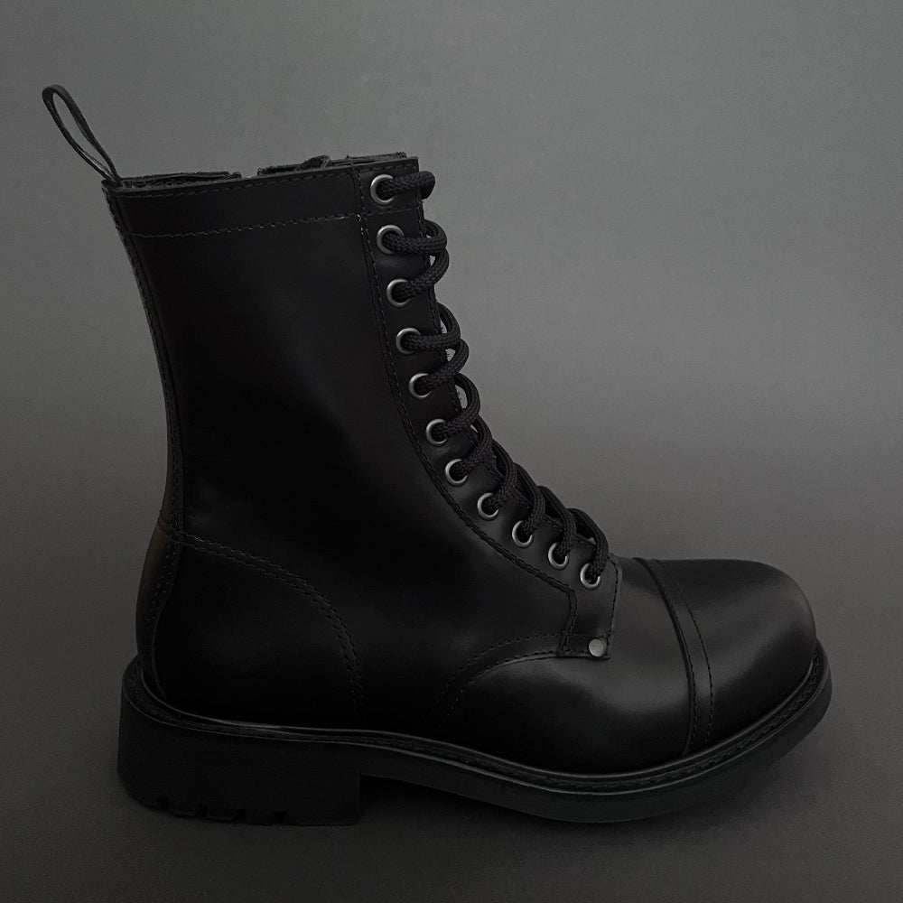Black leather boot with multiple eyelets on a dark gray background